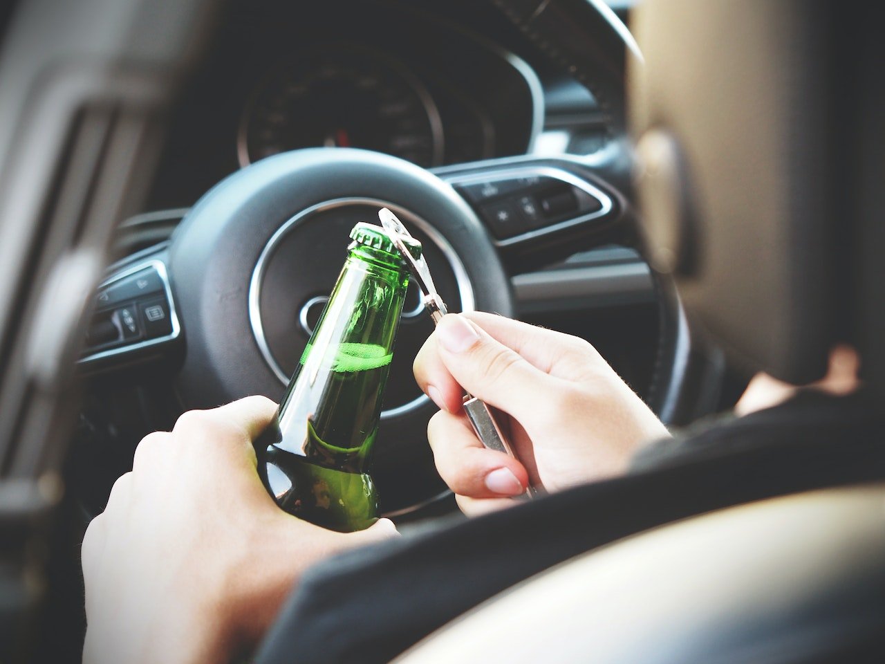 stock photo person drinking beer in car