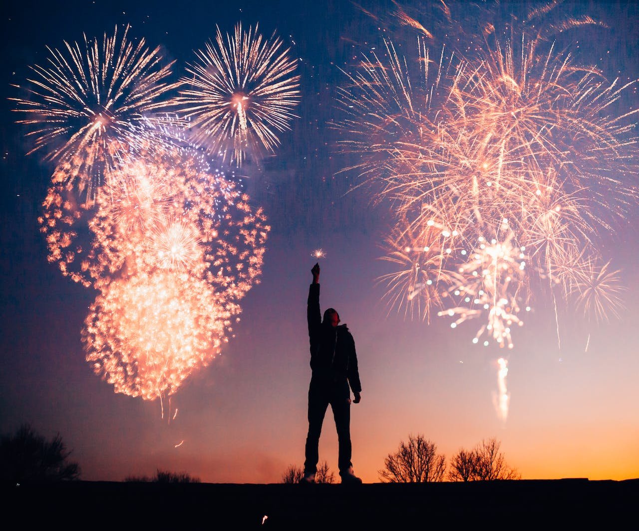 Happy New Year 2024 from the David Smith Law Firm, PLLC image of fireworks and person celebrating new year