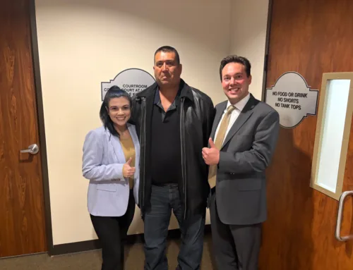 Client celebrating with attorneys after securing a not guilty verdict in a courtroom, showcasing a moment of relief and victory.