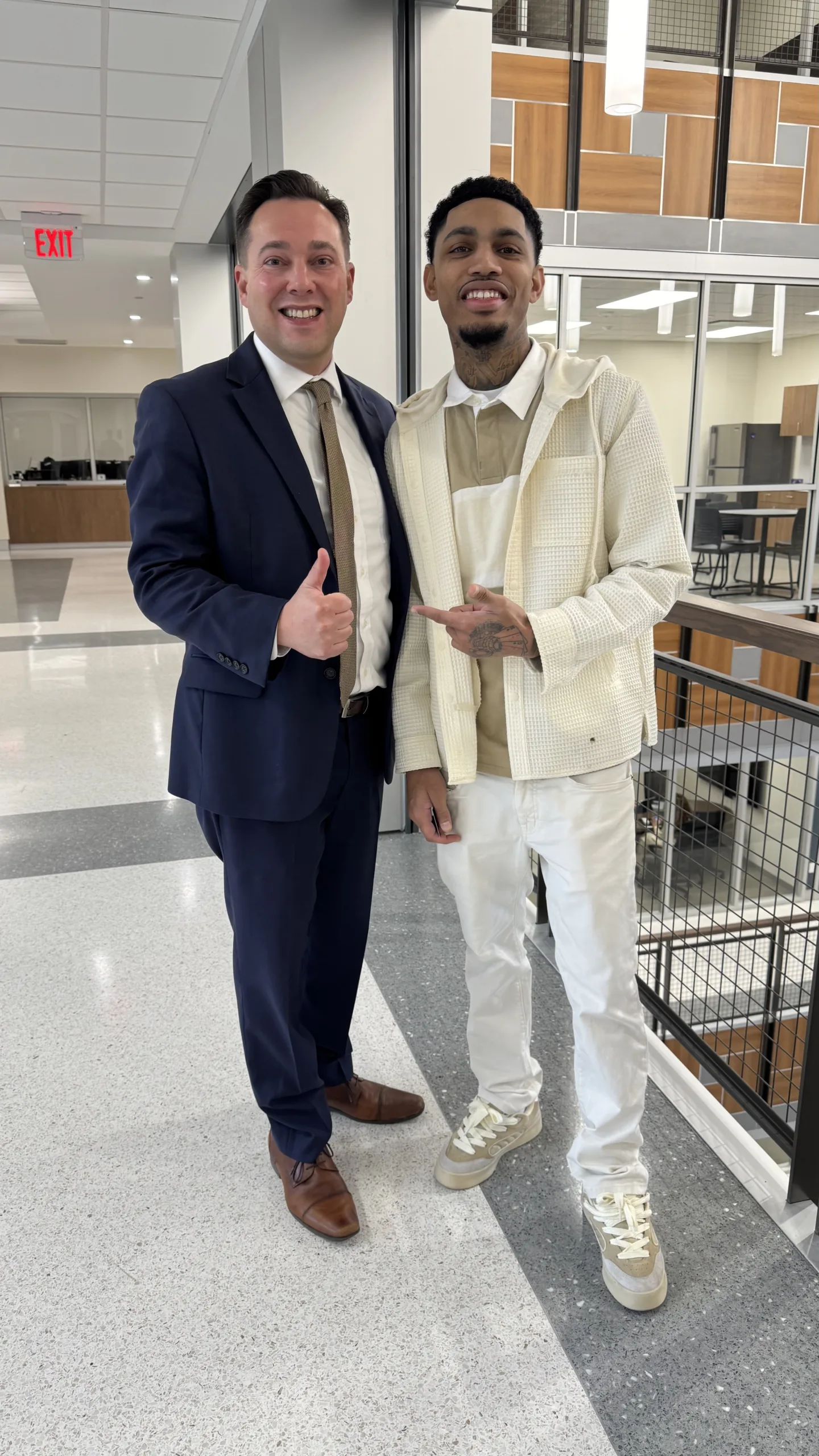 A man wearing a suit and tie standing in front of a building