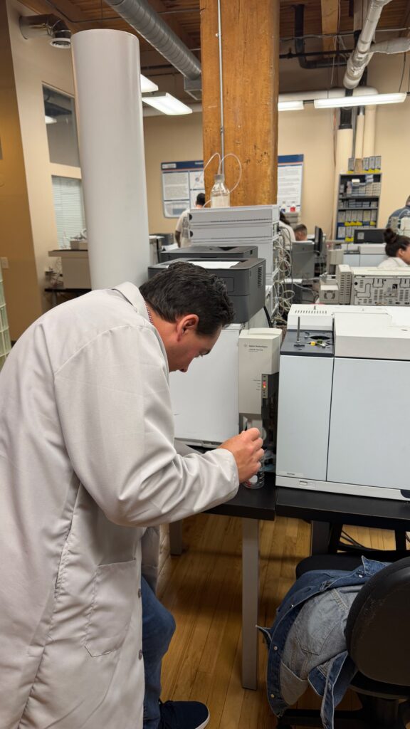 David Smith Earns Forensic Lawyer-Scientist Designation and Highest Score on October 2026 Exam 1 David Smith standing in front of a Gas Chromatograph preparing a manual injection.