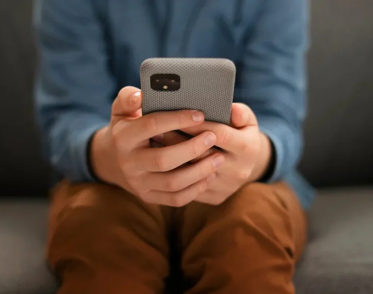 A hand holding a remote control